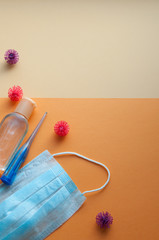 Protective face masks, thermometer and hand  sanitizing gel bottle on neutral background. Concept of coronavirus pandemic. Virus and COVID-19 self protection.