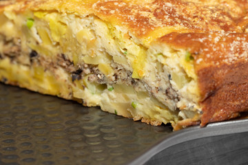 Homemade yeast-free cake on kefir with a filling of canned fish and potatoes, close-up.