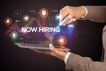 Close-up of a touchscreen with NOW HIRING inscription, business opportunity concept