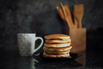 stack of pancakes with a cup of tea on the marble table