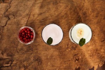 Yogurt with nuts on a wooden background. View from above. Summer food.
