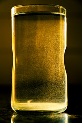 A glass of hot water forming tine bubbles in the water after pouring water in the glass under...