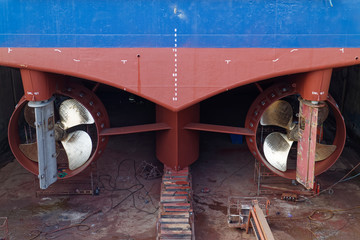 Looking down at the stern of a Vessel in Dry Dock with the newly polished blades of the Propellors,...
