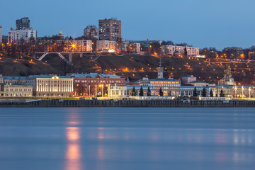 Fototapeta premium A unique perspective of Nizhny Novgorod in the evening with the city lights on against the backdrop of a beautiful sky and sunset