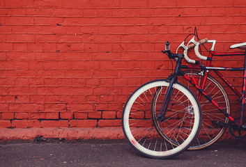 Zwei alte Fahrräder parken an der Wand aus rotem Backstein. Platz kopieren