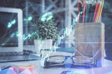Financial chart hologram with glasses on the table background. Concept of business. Double exposure.