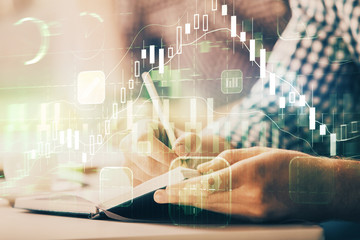 Multi exposure of two men planing investment with stock market forex chart.