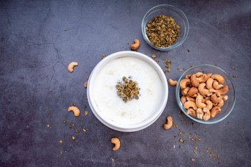 Bowl of cereal matcha oat granola with oat milk, cashew nuts on Black Background. vegan food