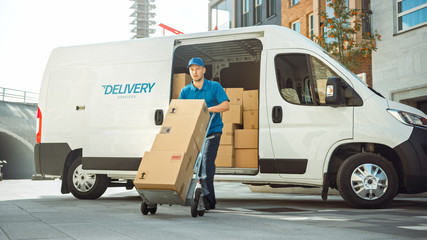 Delivery Man Pushes Hand Truck Trolley Full of Cardboard Boxes Hands Package to a Customer. Courier...