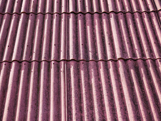 Red asbestos roof top close up shot on  a bright sunny day.