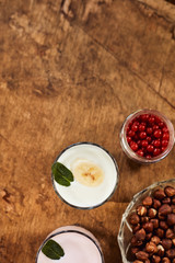 Yogurt with nuts on a wooden background. View from above. Summer food.