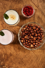 Yogurt with nuts on a wooden background. View from above. Summer food.