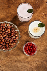 Yogurt with nuts on a wooden background. Side view. Summer food.