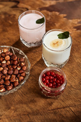 Yogurt with nuts on a wooden background. Side view. Summer food.