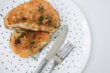 Birmingham eggs with bread on ceramic plate, fork and knife