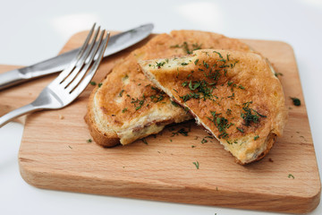 Toast with egg. Birmingham eggs on wooden plate, fork and knife