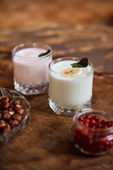 Yogurt with nuts on a wooden background. Side view. Summer food.
