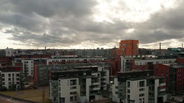 Panoramic city // Aerial shot of Helsinki urban cityscape on a cold day with dramatic cloudy sky and sunlight