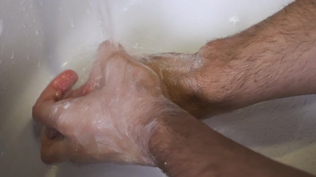 A Person Performing A Thorough Hand Washing Under The White Sink. -close up shot