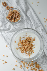 Porridge flakes in a bowl with milk. Granola for Breakfast with yogurt and walnuts.