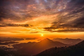 High angle view of a breathtaking sunset scenery in the golden cloudy sky over the hills