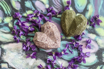 Fototapeta na wymiar Organic handmade soap shampoo on purple flowers background.
