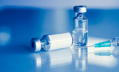 Vaccine vial dose flu shot drug needle syringe,medical concept . blue background. selection focus.