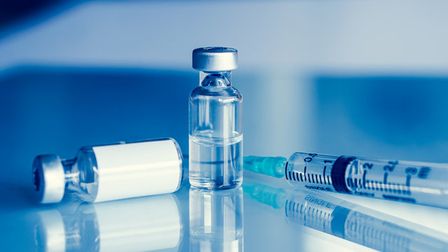 Vaccine vial dose flu shot drug needle syringe,medical concept . blue background. selection focus.