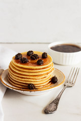 stack of sweet  pancakes  with fir cone jam on white plate.