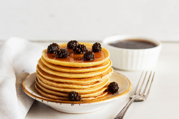 stack of sweet  pancakes  with fir cone jam on white plate.