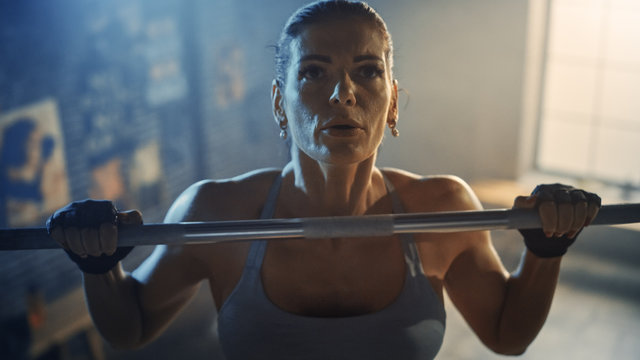 Beautiful Strong Woman Doing Pull Ups in the Hardcore Gym. Gorgeous Professional Female Athlete Does Power, Strength and Cross Fitness Exercises and Everyday Workout Routine.