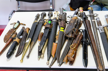 Sale of antique Dirks and daggers. A table with daggers for sale spread out on it.