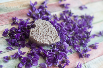 Obraz na płótnie Canvas Organic handmade soap shampoo on purple flowers background.