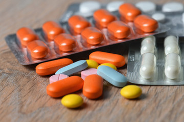 Assorted colored tablets and tablet packaging close-up on the table. Concept of protection and treatment of coronavirus infection.