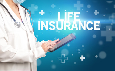 doctor writes notes on the clipboard with LIFE INSURANCE inscription, first aid concept