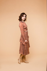 Full length stock photo of a beautiful wavy-haired brunette Caucasian woman wearing lovely coral...