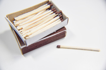 Box of matches on the white background and one outside
