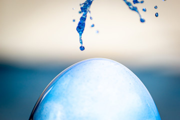 blaue Farbe platscht sprenkelt auf weisses Ei