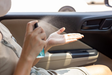 Asian woman spraying alcohol spray or anti bacteria spray for prevent spread and kill virus, bacteria, germ, coronavirus. Female clean her hands with alcohol based hand washing spray. hygiene concept.