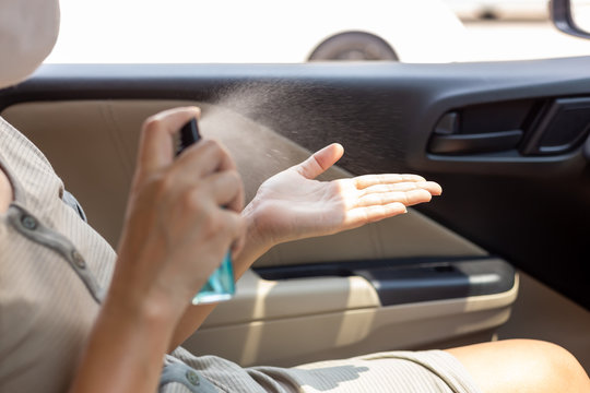 Asian woman spraying alcohol spray or anti bacteria spray for prevent spread and kill virus, bacteria, germ, coronavirus. Female clean her hands with alcohol based hand washing spray. hygiene concept.