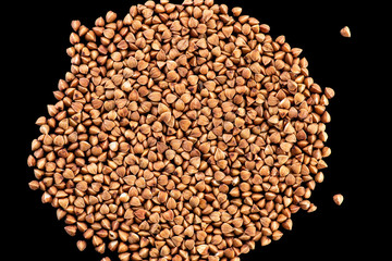 buckwheat brown seeds on a black background top view