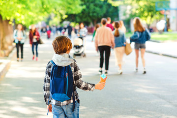 Boy holding ice cream outdoors. Kid walking at park in sunny day. Stylish boy outdoors.