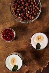 Yogurt with nuts on a wooden background. View from above. Summer food.