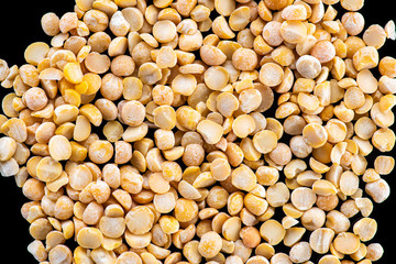 halves of dried crushed pea seeds on a black background