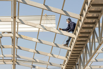 Man working on roof metal sheet on Light steel Truss and Frame construction.