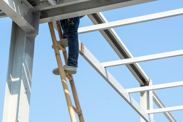A man climbing on a wooden ladder.