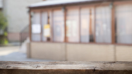 Empty wooden table from above on blur light golden bokeh cafe restaurant, bar on a dark background. with a ray of light on the table.