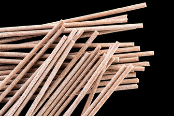 plain and brown spaghetti made from buckwheat flour next to a white or black background
