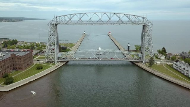 Drone shot of Duluth Lift Bridge with traffic crossing and small boat
