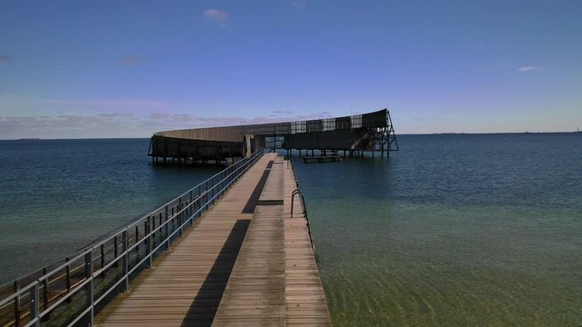 Unbelievable dolly shot over modern-looking curvaceous dock in touristic capital city